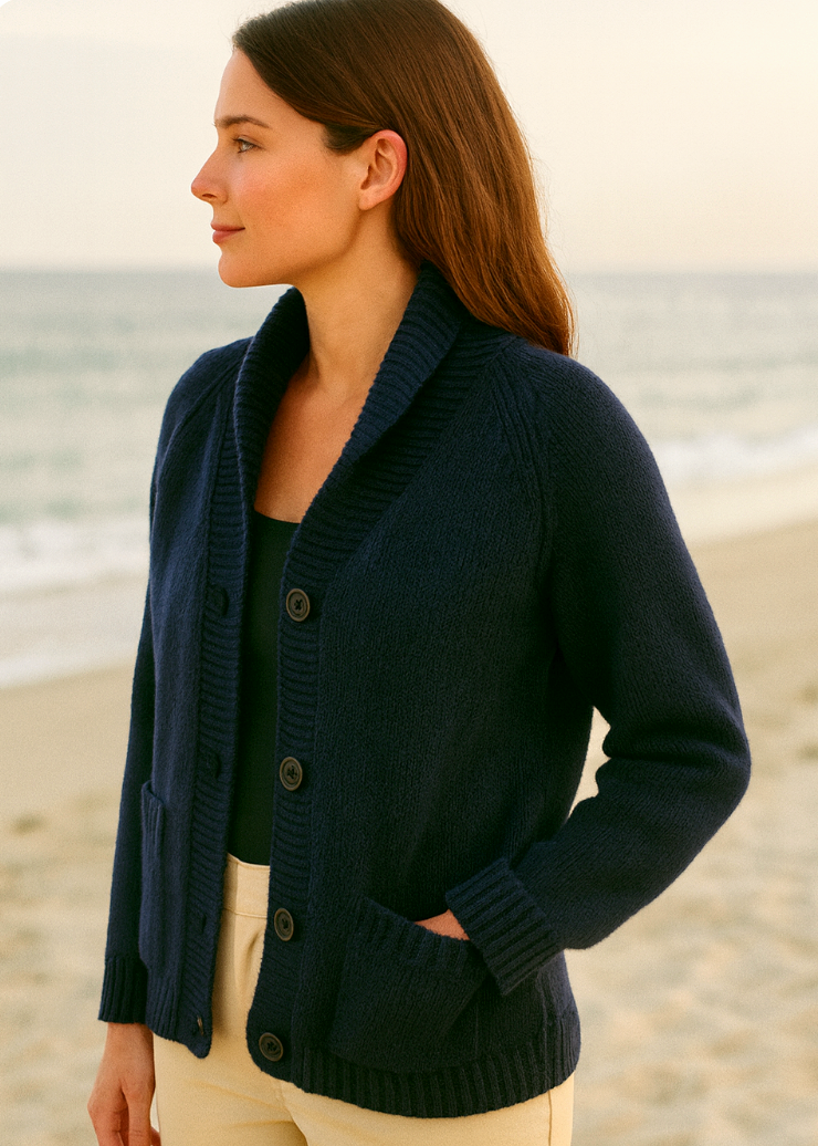 Woman wearing a NWPRT navy cardigan on a beach