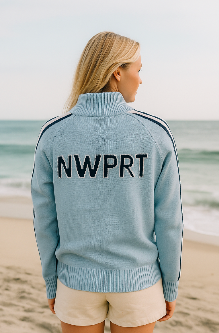 Person wearing a light blue 1/4 jacket with 'NWPRRT' on the back, standing on a beach.